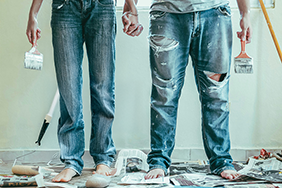 Legs of a woman and man in jeans, which show stains from painting work